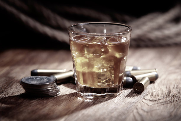 木桌上放着加冰的威士忌和弹药，还有旧的一元银币图片下载