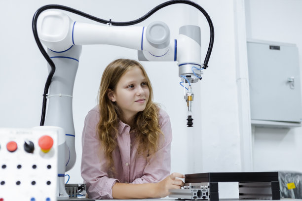 教室桌子上的女孩高加索教育电子机械臂。学习创新机器人电子未来人工智能。系统技能培训。STEM教育理念。图片下载