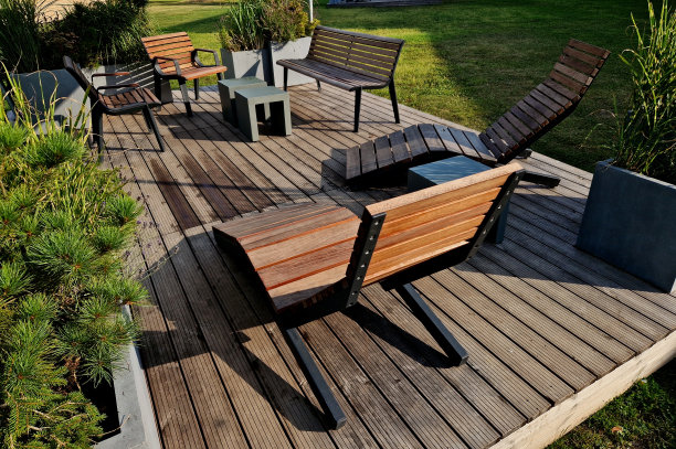 广场树下的摇椅人行道。热带木材制成的单人躺椅。它们由棕色木板、板条、钢架、松木、木板、户外制成，很舒适图片下载