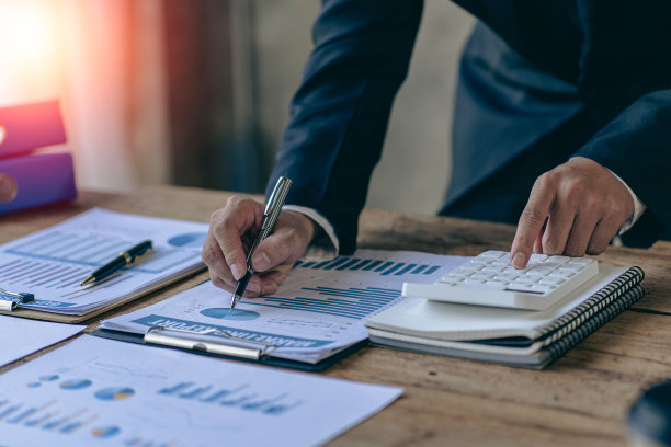 商人分析投资图表，按下计算器按钮计算单据，财务单据在数码平板电脑上的会计近景图像图片下载