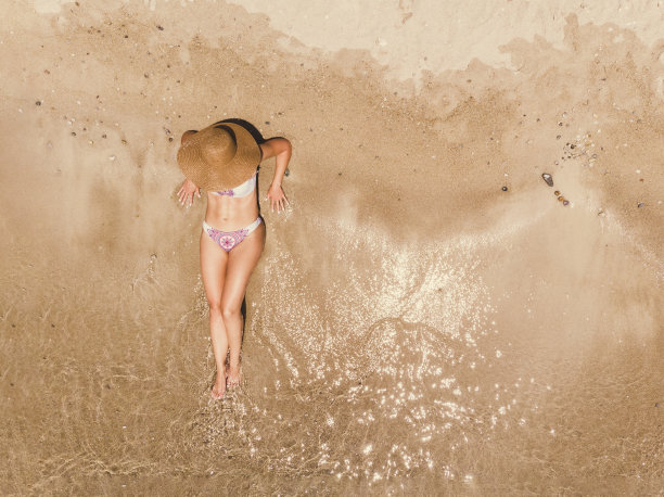 一个女人在海滩上放松的鸟瞰图图片下载