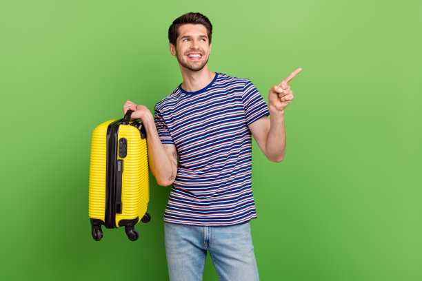 年轻人的照片旅行社便宜的低成本机票和直接的手指模拟航空公司与行李箱孤立的绿色背景图片下载