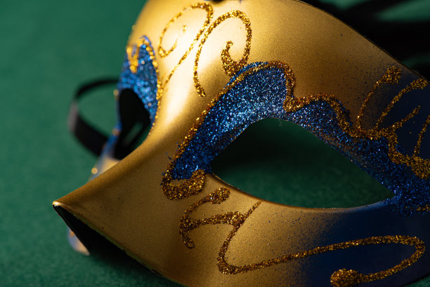 狂欢节面具，美丽的狂欢节面具放在绿色毛毡背景上，选择性聚焦。图片下载