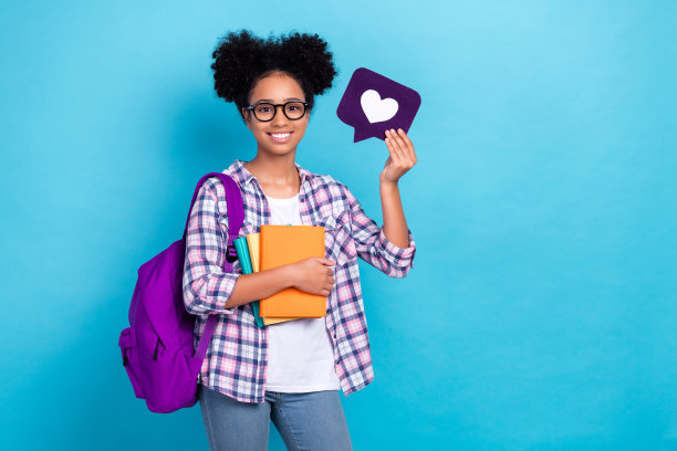 照片积极的好女孩穿着格子衬衫背包在肩上拿着书像图标孤立的蓝色背景图片下载