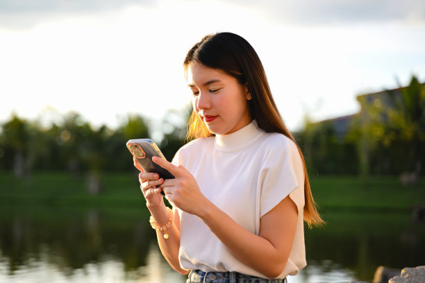 一位女士正在使用智能手机进行各种日常活动。这张照片质量很好。图片下载