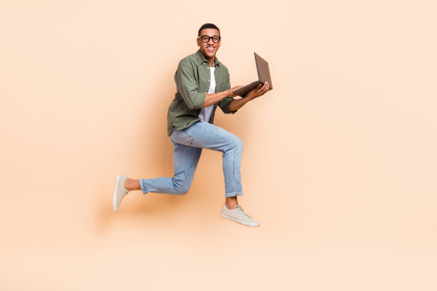 时髦酷的家伙穿着卡其布衬衫跳高工作现代装置孤立米色背景的全长照片图片下载