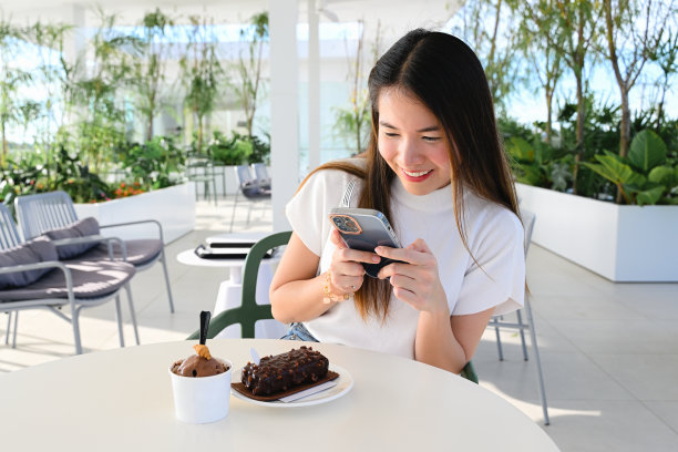 一位女士正在使用智能手机进行各种日常活动。这张照片质量很好。图片下载