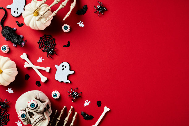 万圣节快乐的节日概念。平铺构图与头骨，南瓜，怪物的手，鬼，骨头，蜘蛛在红色的背景。前视图。图片下载