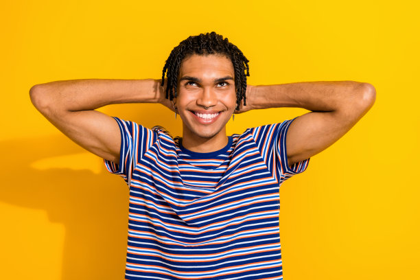 开朗平和的男人的肖像，露齿微笑，双手在头后抬头，空白空间孤立在黄色的背景图片下载