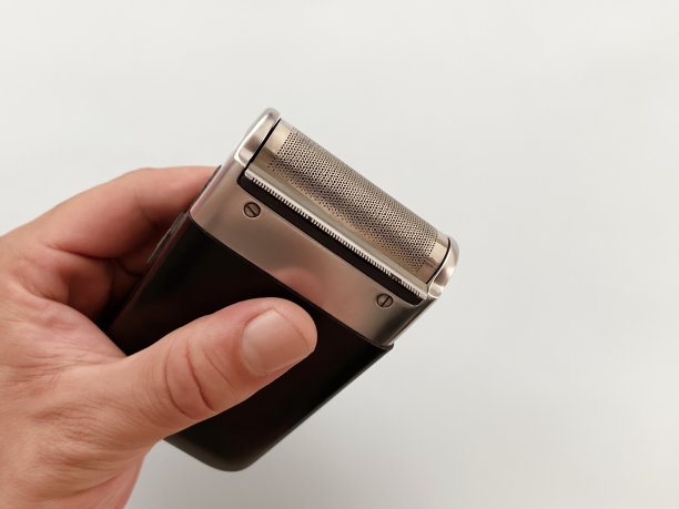 男性手持老式电动剃须刀机。电动刮胡刀图片下载