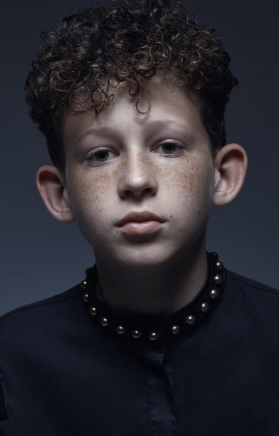一个长着雀斑、卷发和大耳朵的小男孩的肖像。图片下载