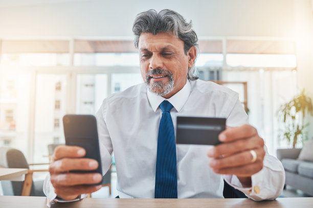 电话，信用卡和商务人员用于网上购物，股票市场投资和家庭办公室支付。手机，银行和专业的印度人，老板或企业家进行互联网交易图片下载