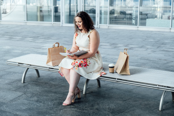 自我保健健康期刊。日日夜夜反思日记，成功日记。快乐的大码女人在户外写日记图片下载