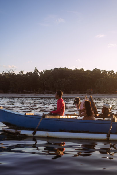 亚洲女游客记录木船上钓鱼的渔夫图片下载
