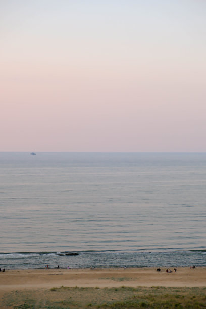 透过窗户可以看到里海、海滩和五彩缤纷的粉蓝色天空上的日出。图片下载