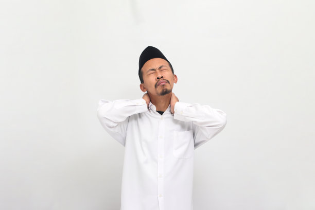 年轻的印尼男子按摩他的脖子，孤立在白色背景上图片下载