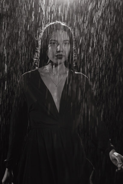 在黑色的画室里，穿着裙子的女孩被雨淋湿了图片下载