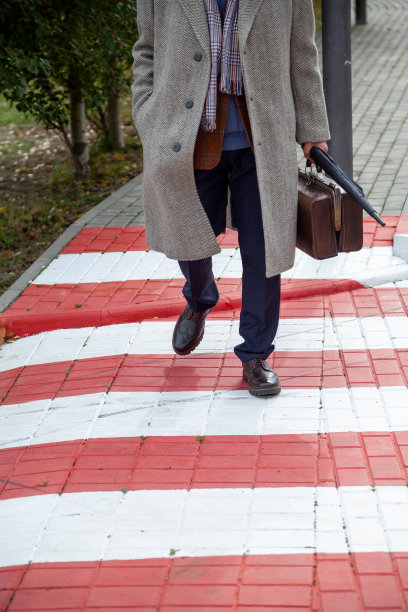 拿着包和外套的人走在街上图片下载