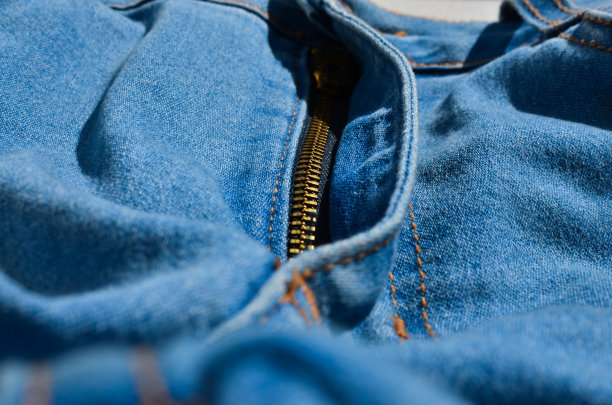 牛仔裤接缝的特写，显示出整齐和精确线条的细节。完美的时尚和服装项目。图片下载