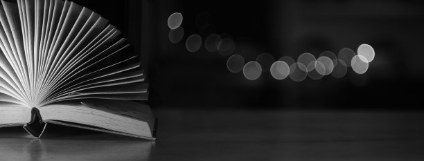 打开书，精装书在木桌上模糊散景球黑色背景。回到学校，教育，读书。大的拷贝空间图片下载