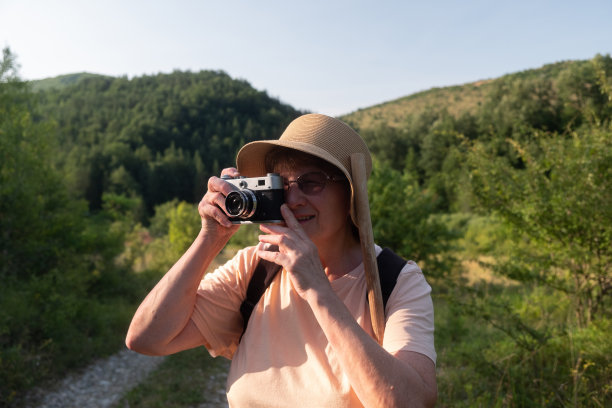 老妇人在山里用老式照相机拍照图片下载