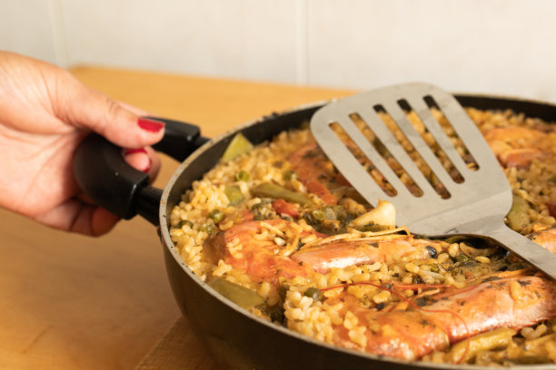 手里拿着家里自制的海鲜饭。西班牙美食和地中海美食的概念。图片下载