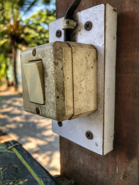 一个虾电源插座，只需点击一下按钮，就可以连接到一个木制的建筑杆子上图片下载