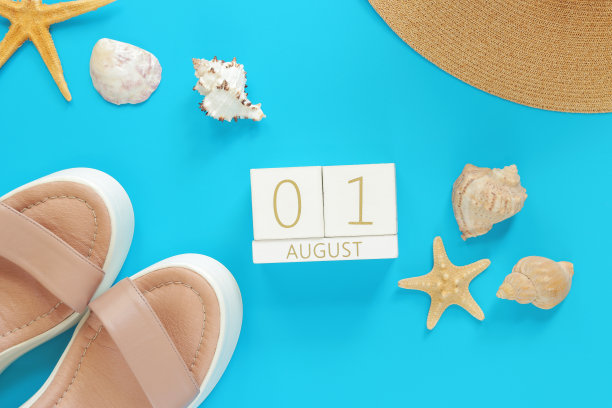 8月1日。木制日历上的蓝色背景与夏季配件图片下载
