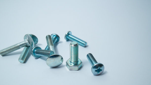 白色背景上的一组螺栓。建筑的抽象。工业背景。螺丝和螺栓宏照片，螺丝背景，钢螺丝，螺栓宏。图片下载