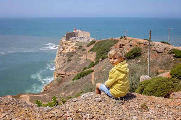 一家人带着孩子，在葡萄牙纳扎雷世界上海浪最大的海滩上游玩图片下载