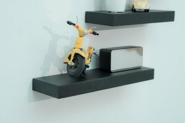 木制架子上摆放着漂亮的植物，闹钟，玩具车和浅色墙上的书图片下载