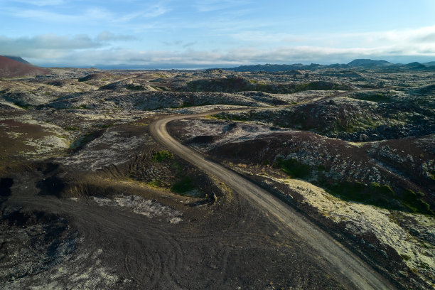 这条土路一直延伸到熔岩地带的地平线。俯视图，无人机拍摄的照片。Helgafellssveit,冰岛。图片下载