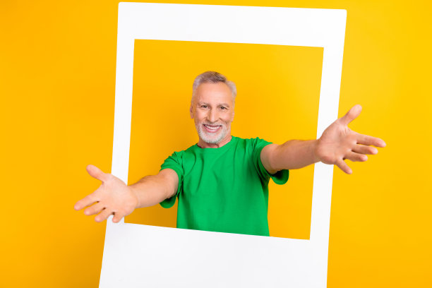 开朗兴奋的老人张开双臂的照片通过纸质相册套卡邀请你孤立在黄色背景上图片下载