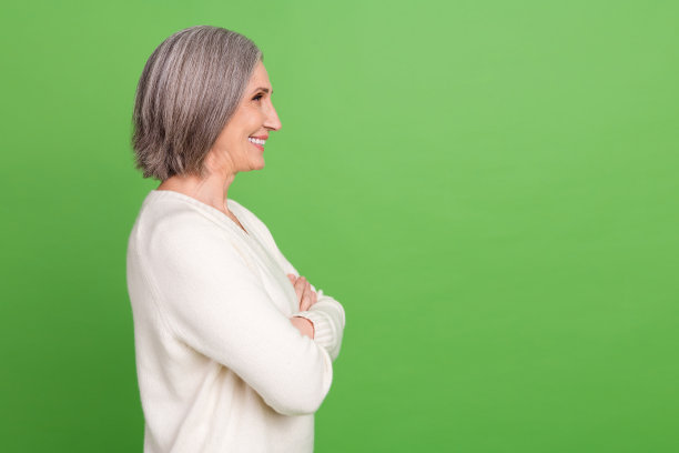 侧面视图肖像迷人的退休女士办公室职员抱着双臂看空空间有趣孤立的绿色背景图片下载