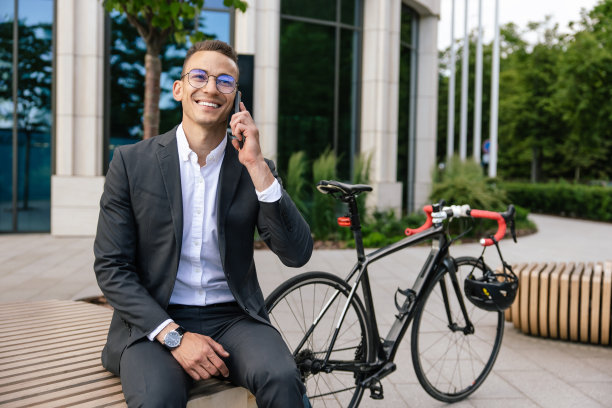 穿着优雅西装的年轻人正在打电话，看起来很满足图片下载