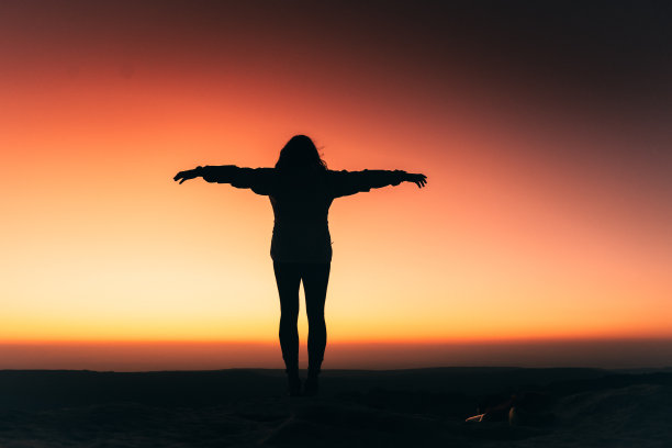 伸出双臂的女人的剪影图片下载