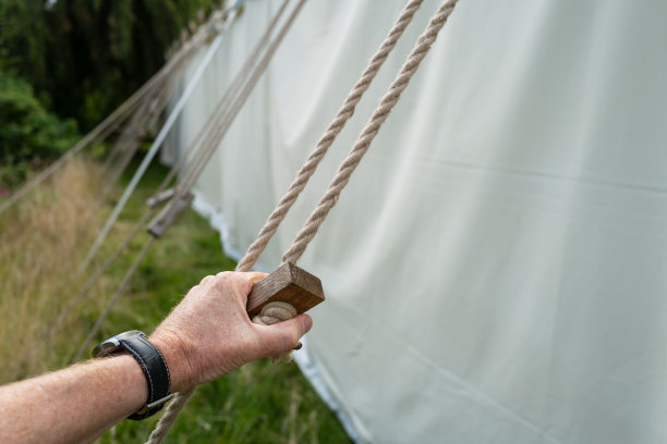 帐篷安装工正在调整婚礼帐篷上粗气绳的张力。图片下载