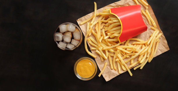 快餐。牛皮纸薯条，加冰和芥末的可乐，俯视图图片下载