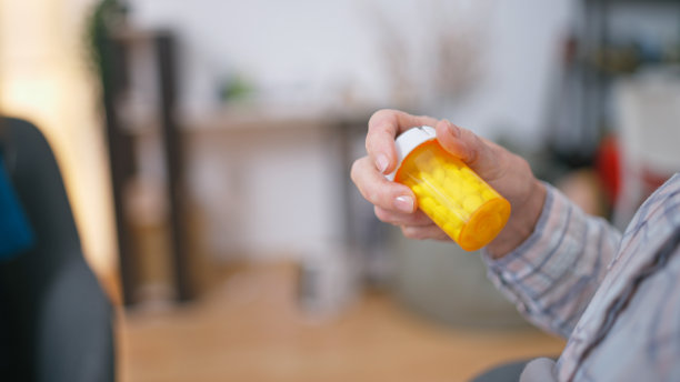 一个成熟的女人拿着一瓶药，通过一个社会项目接受免费药物图片下载