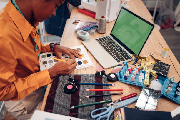 女时装设计师在工作室工作并绘制新服装系列草图，时装设计理念。图片下载