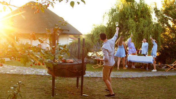 人在自然中准备食物。一群年轻人聚在一起烧烤。朋友们玩得开心，做饭，喝酒。他们在一个阳光明媚的日子里在大自然中聚会。图片下载
