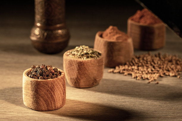 木制的农家桌子上放着各种香料的木杯子图片下载