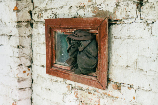 白色灰泥的废弃砖墙上被毁坏的旧窗户图片下载