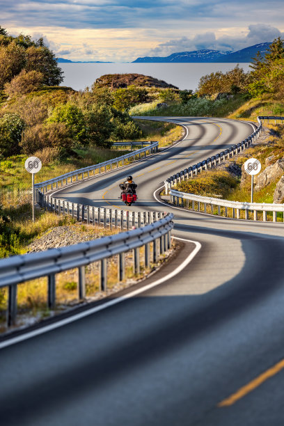 一对夫妇在挪威蜿蜒的大西洋公路上骑摩托车。图片下载