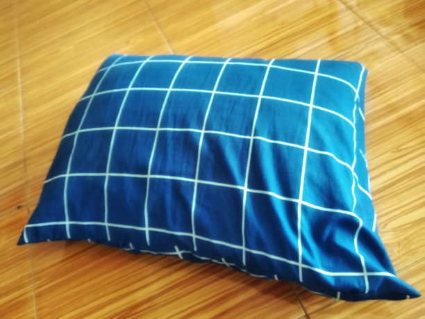 蓝色棉质枕头在木板木材纹理背景图片下载