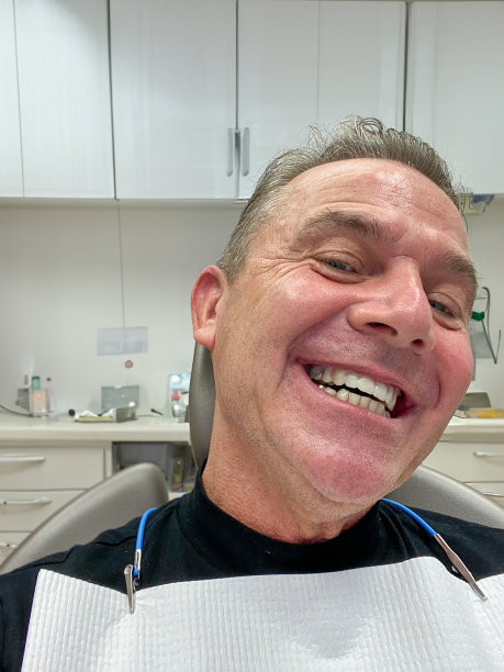 有魅力的男人歪着头，露出他的新牙图片下载