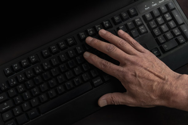 男性的手在RGB灯的游戏键盘上的特写图片下载