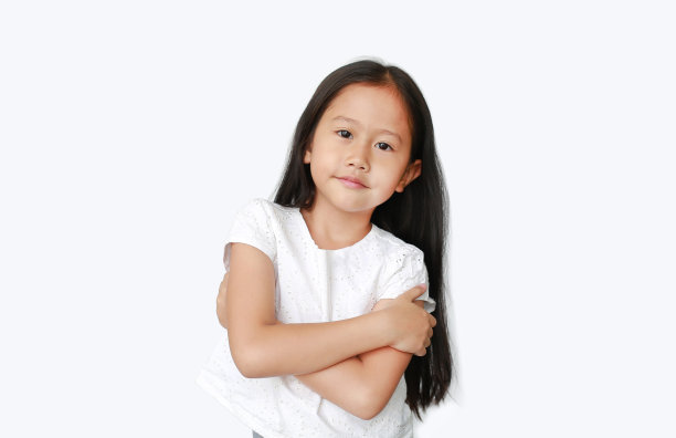 自信的亚洲小女孩抱着胳膊，在白色的背景上孤立地看着镜头。快乐儿童概念。图片下载