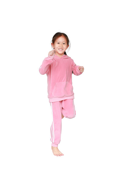 微笑的亚洲小女孩的肖像，穿着粉红色的运动服或运动服，在白色的背景上孤立地奔跑。自由和运动的儿童运动理念。图片下载