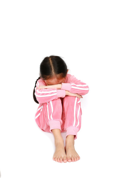 悲伤，孤独和沮丧的小亚洲女孩坐在白色的背景。家庭关系概念。图片下载
